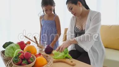 <strong>母女</strong>俩在家客厅里<strong>一起</strong>用混合水果和蔬菜做沙拉。 家庭和人民幸福